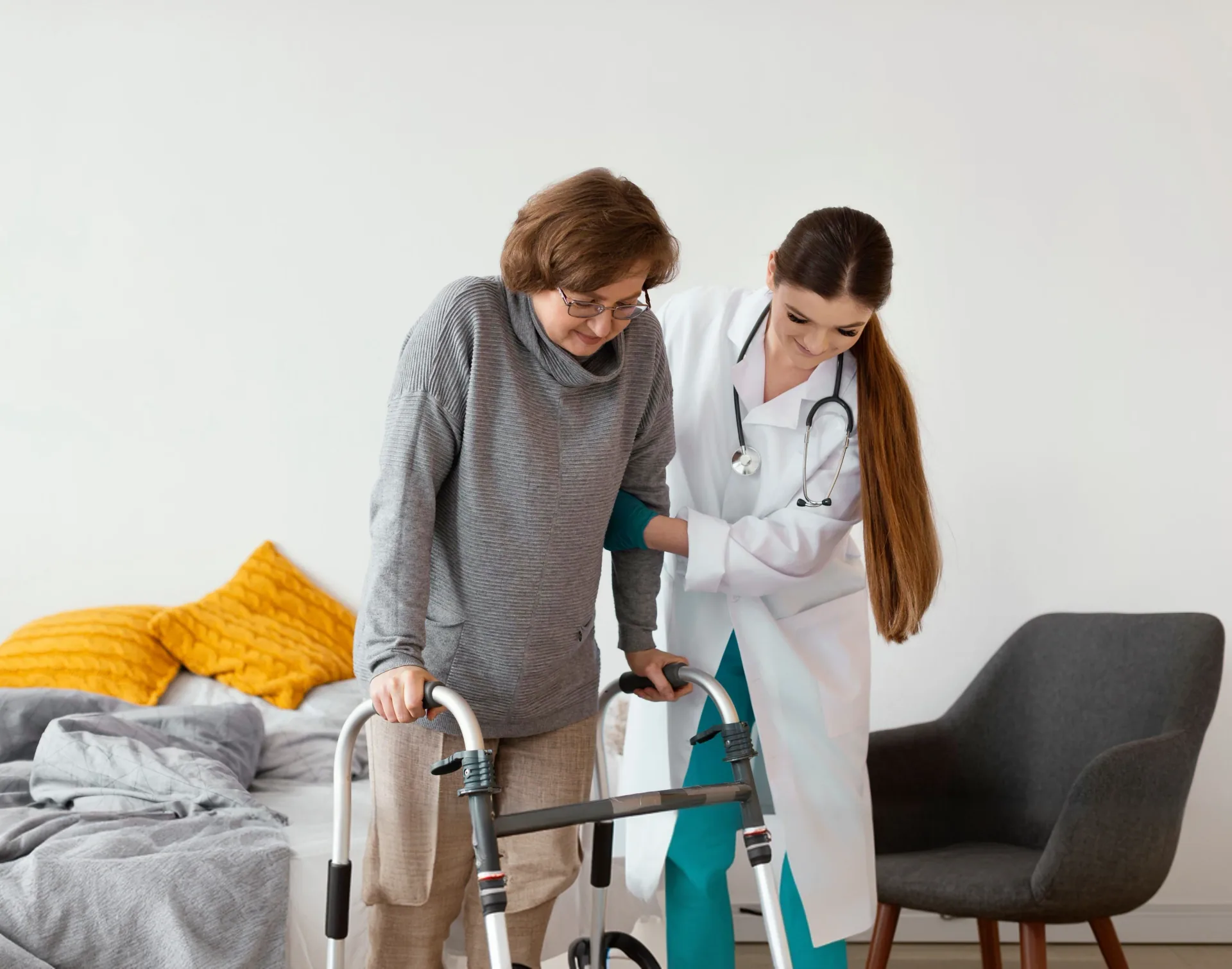 Care worker helping an older person with a walking frame
