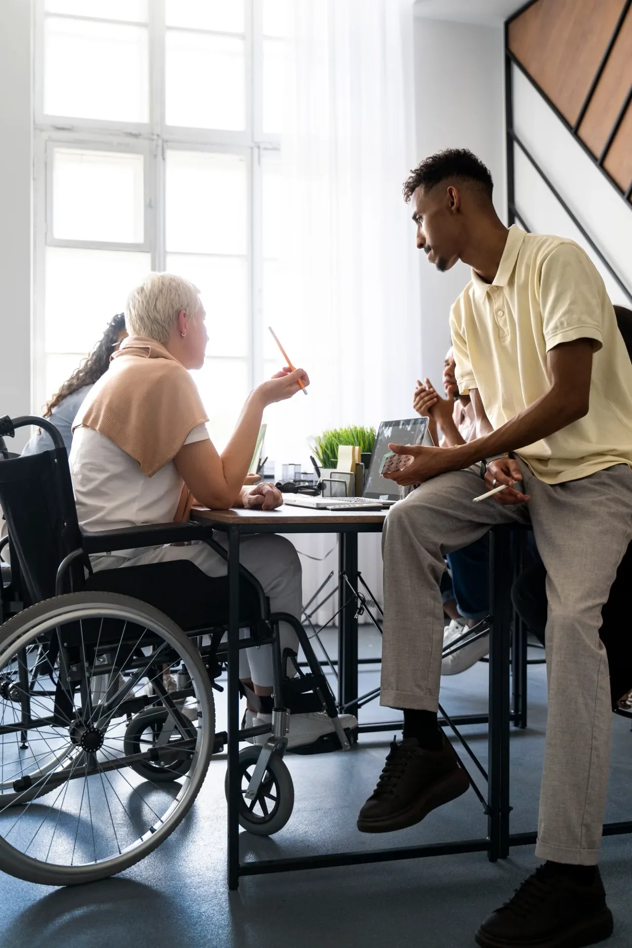 Support worker speaking with a wheelchair user at home