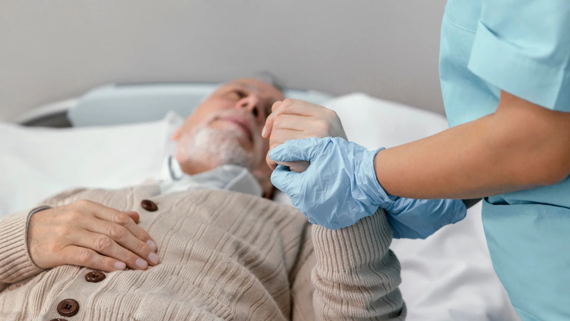 Care worker holding an older person's hand